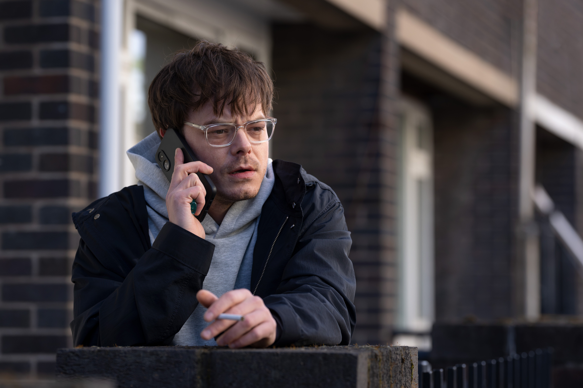 charlie heaton in a new role wearing glasses and on the phone in industry season 4
