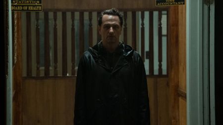 Matthew Rhys as Tom Loflis wearing a raincoat in Widow's Bay