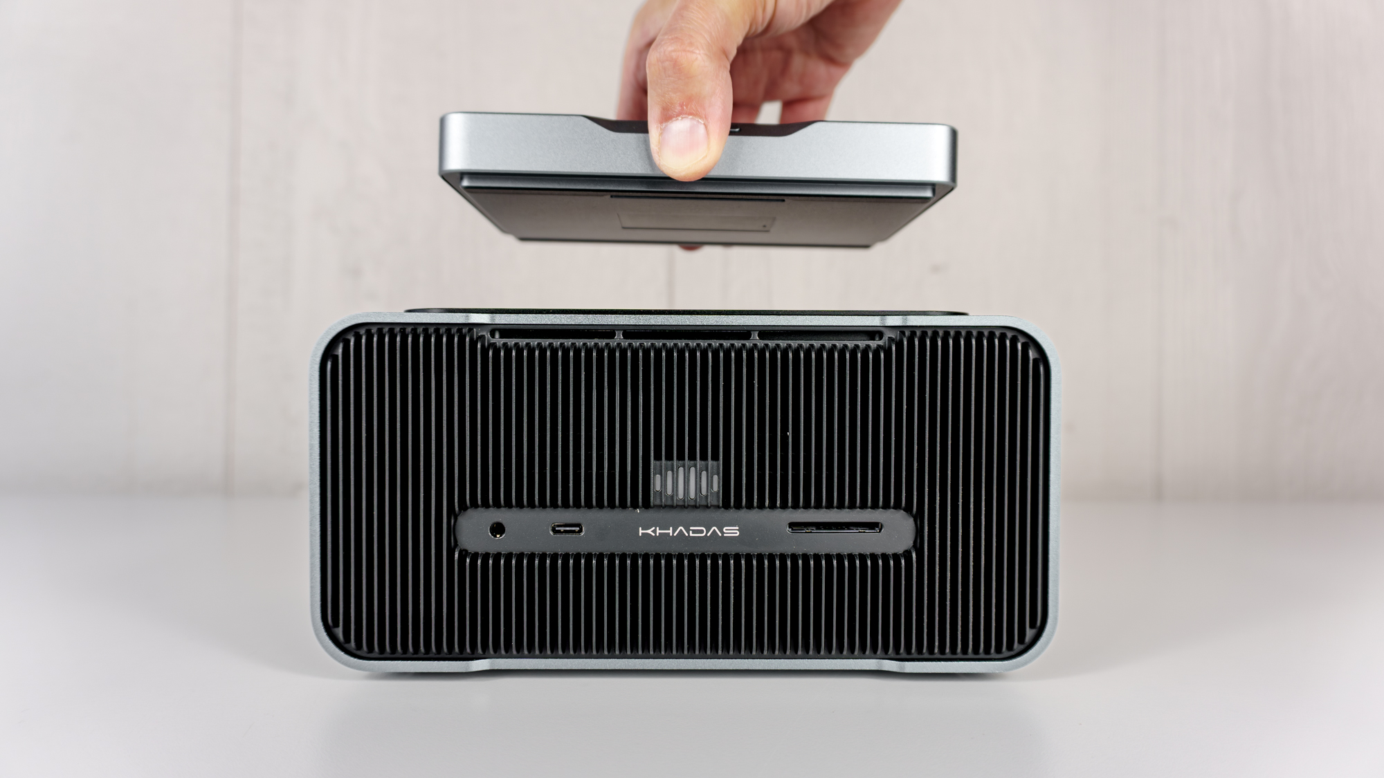 A person docking the Khadas Mind mini PC on the Mind Graphics 2 dock on a table