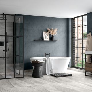 Large bathroom with dark grey wall, black shower enclosure and modern freestanding bath with black taps