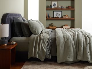 A bedroom with sage a green quilt