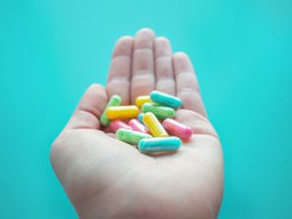 hand holding colorful supplement pills