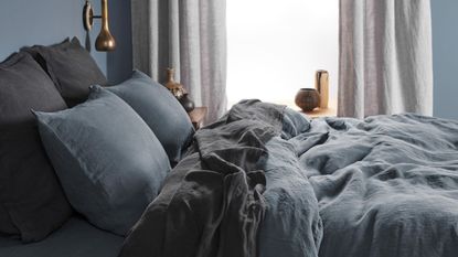 Masculine bedding might look like this - gray and navy linen sheets on a bed.