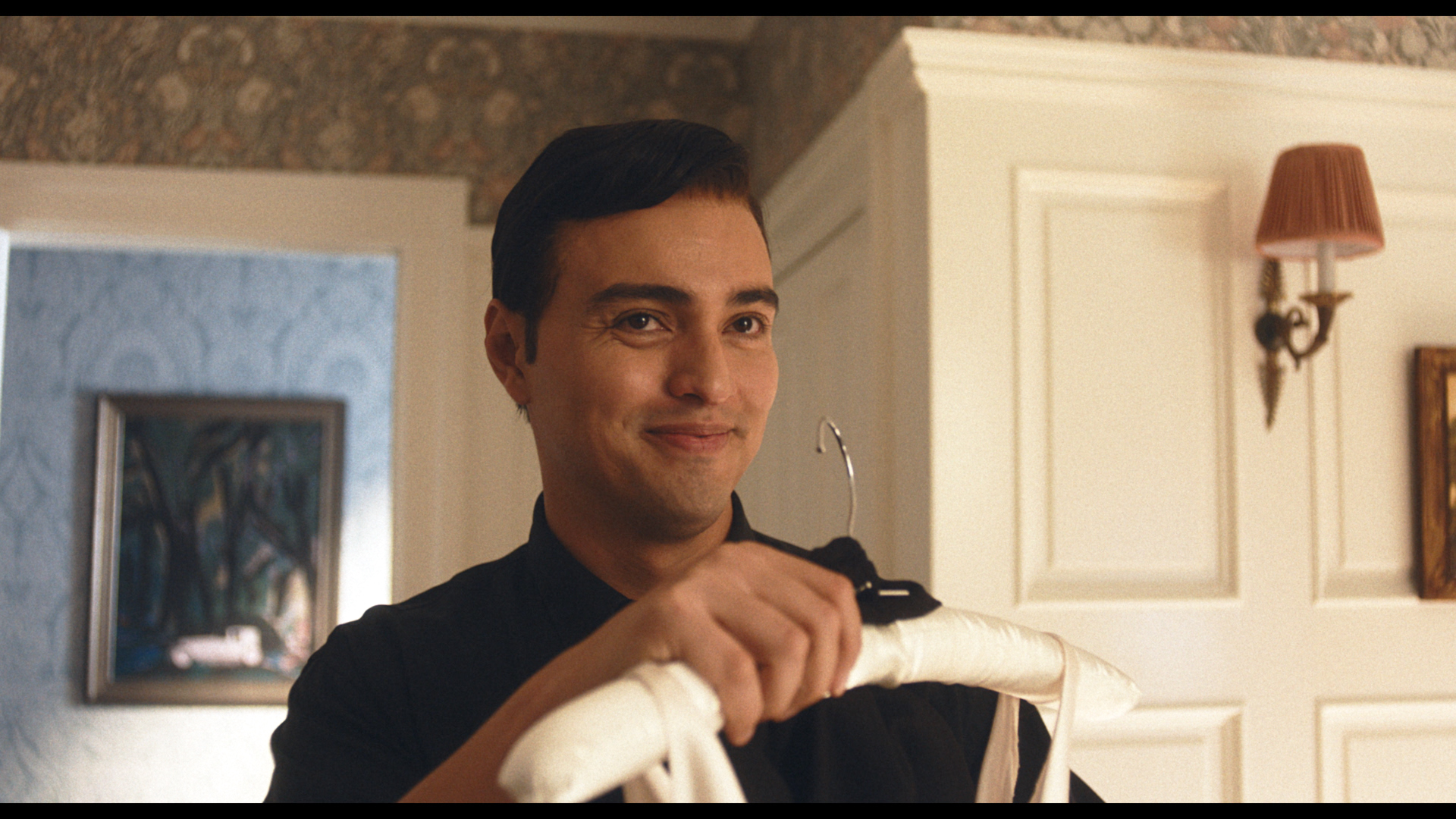 actor playing Narciso Rodriguez holds Carolyn Bessette Kennedy's dress
