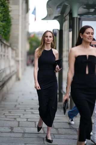 Lauren Santo Domingo wears a black halter dress with black pointy toe flats during Paris Fashion Week.