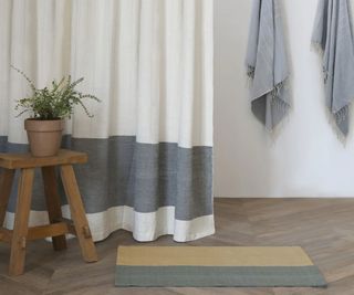 Karo Shower Curtain and towels in a bathroom with a bath mat and wooden step on the side