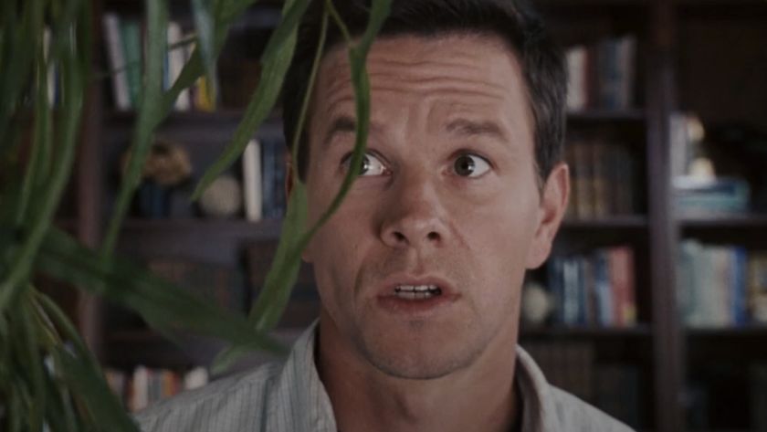 Mark Wahlberg cautiously speaking with a fake plant in The Happening