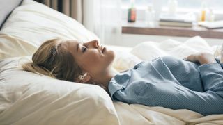 A woman sleeps on her back after practising Progressive Muscle Relaxation for sleep