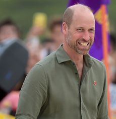 Prince William wearing a green shirt and smiling