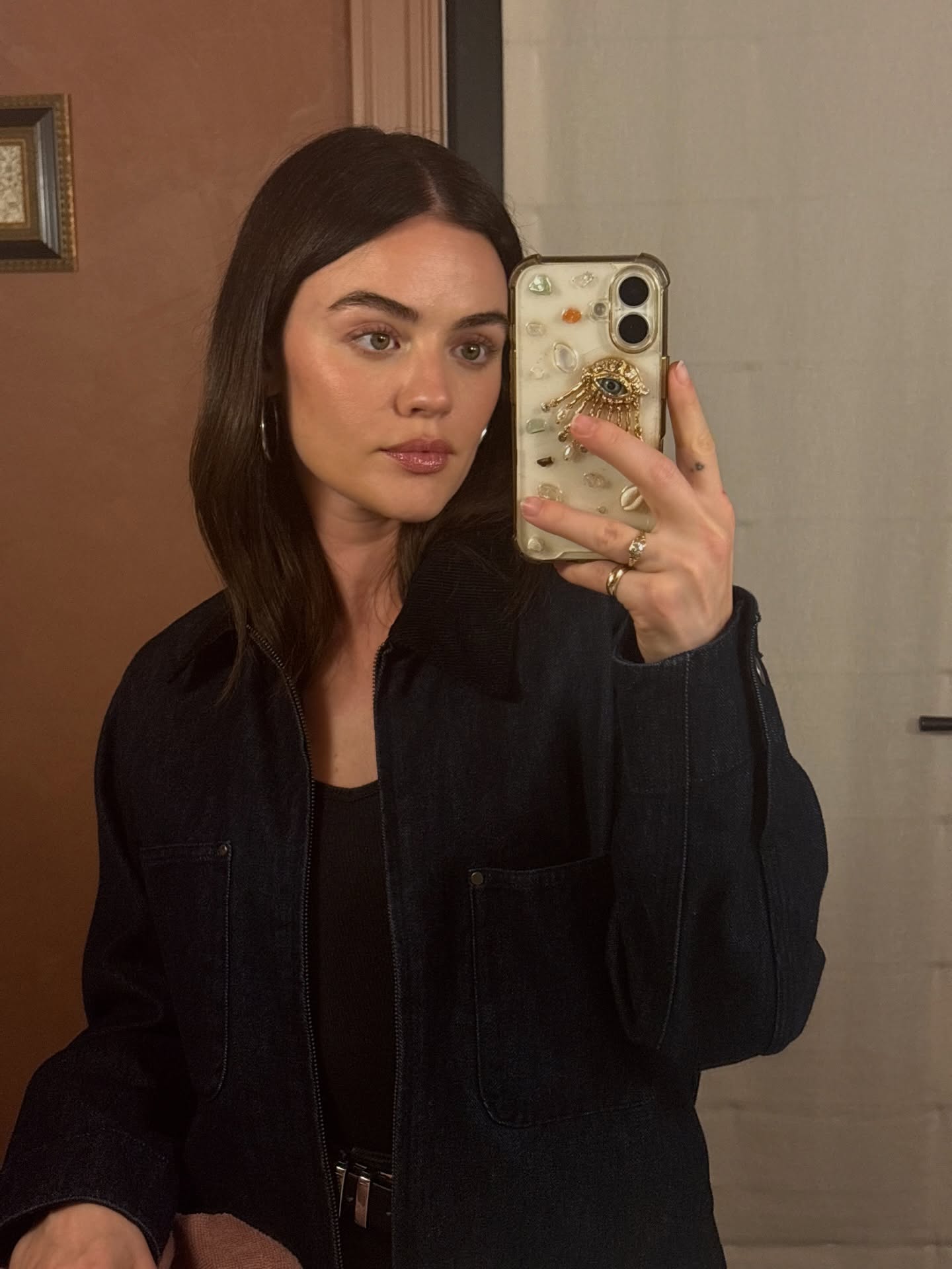 A selfie of Lucy Hale holding a bedazzled phone case
