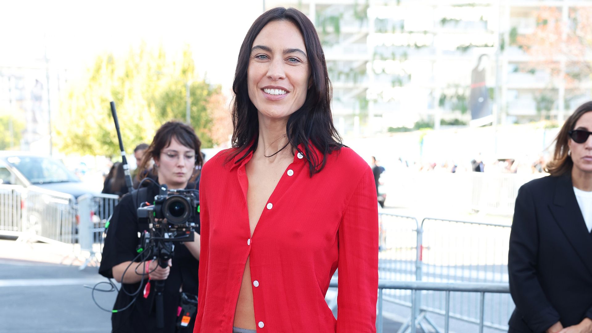 Alexa Chung arrives at the Prada runway show in Milan wearing a red button-down with a sparkly knee-length skirt and black slingback heels.