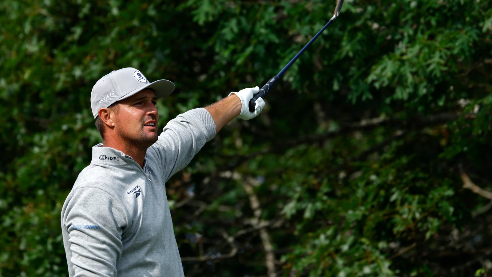 Bryson DeChambeau points left after hitting a tee shot