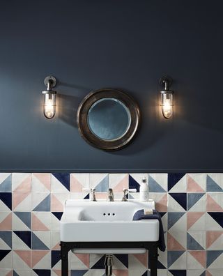 dark blue bathroom with pink tiles and industrial lighting