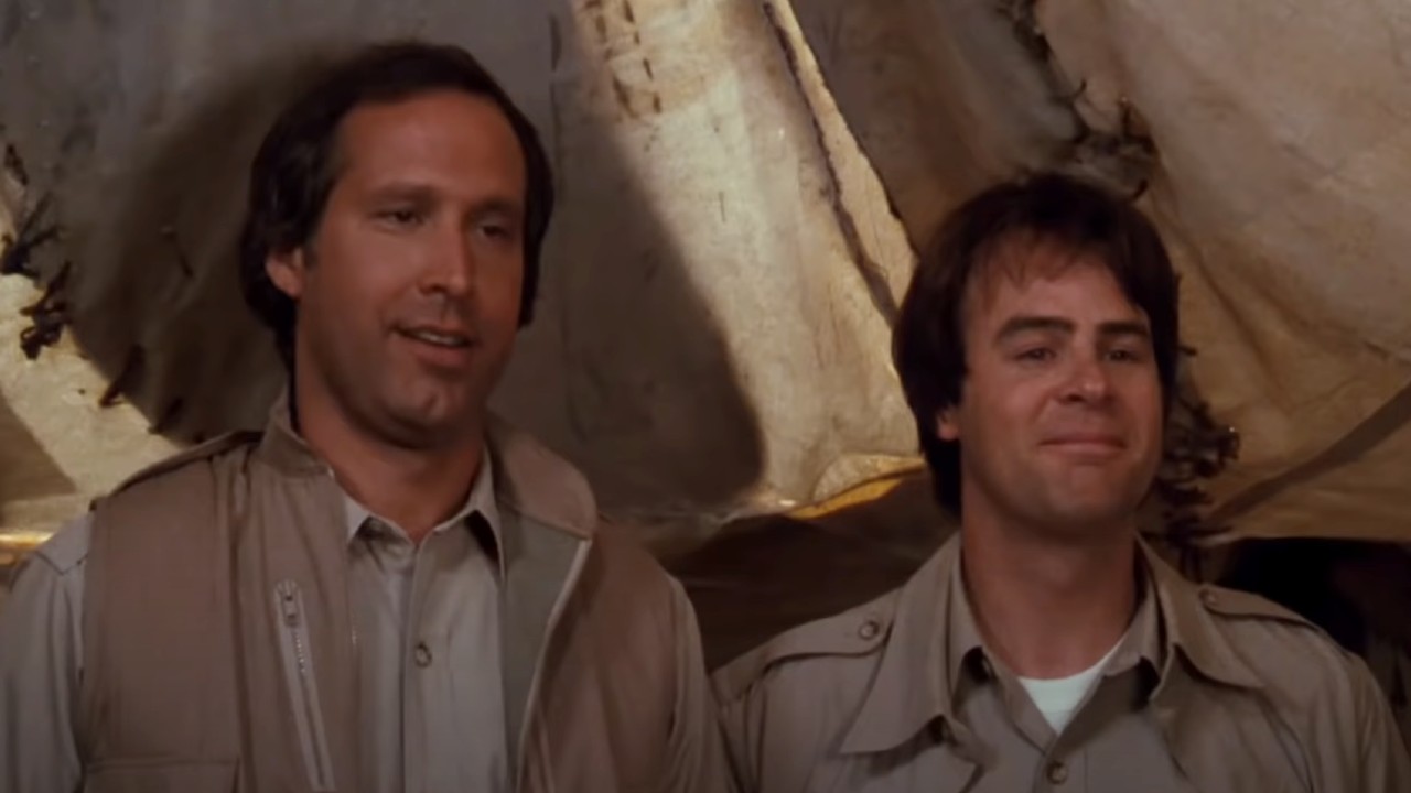 Chevy Chase and Dan Aykroyd standing next to each other in a tent in Spies Like Us.