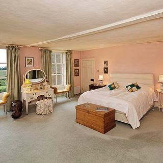 bedroom with peach walls showcase and carpet on flooring