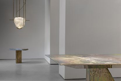 Tables and a hanging light inside gallery space 
