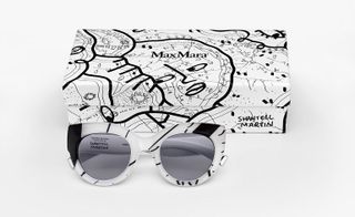 Sunglasses with white frames and black lines, with a box that they come in. The box is white, with black line art by Martin.