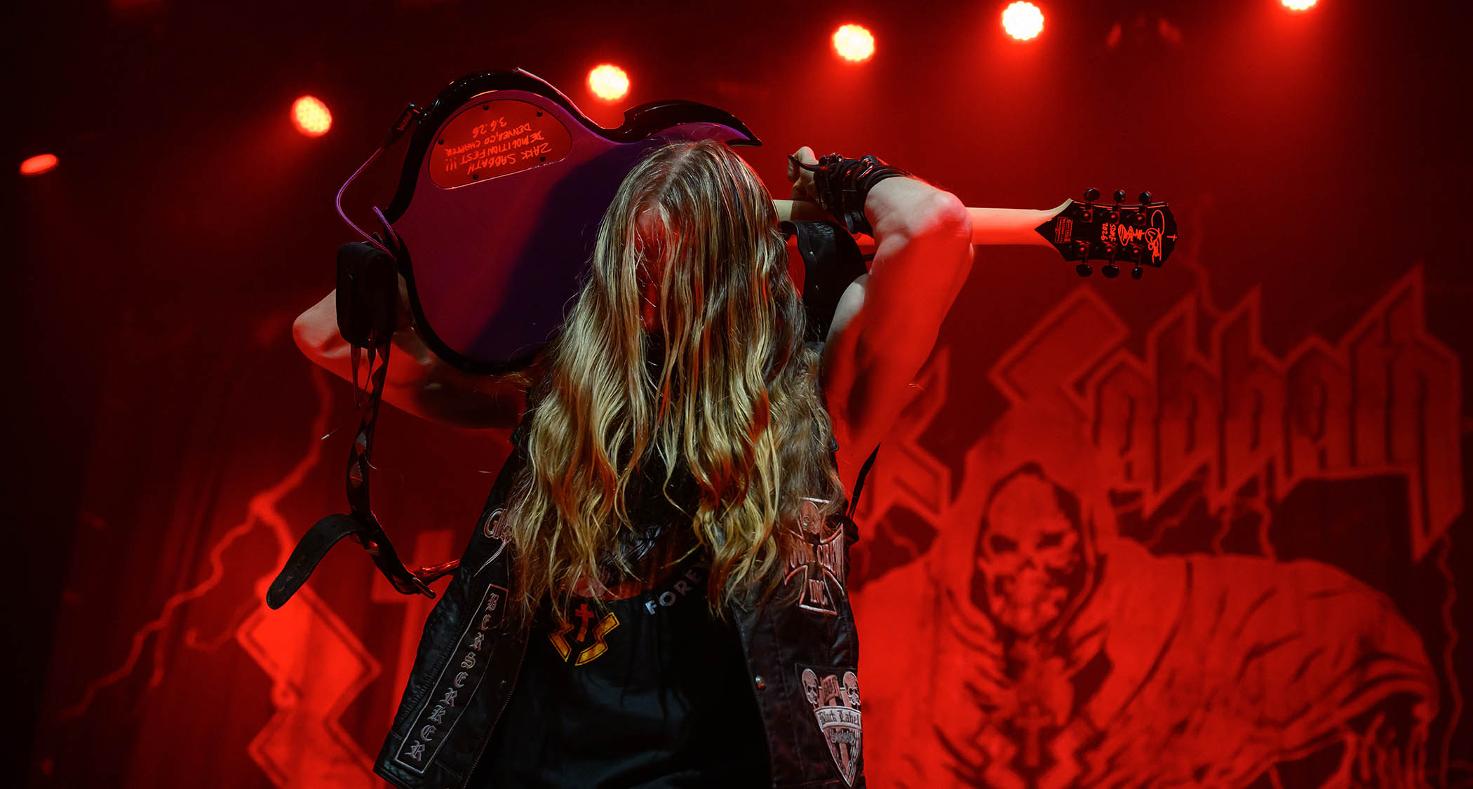 Zakk Wylde plays his guitar behind his head