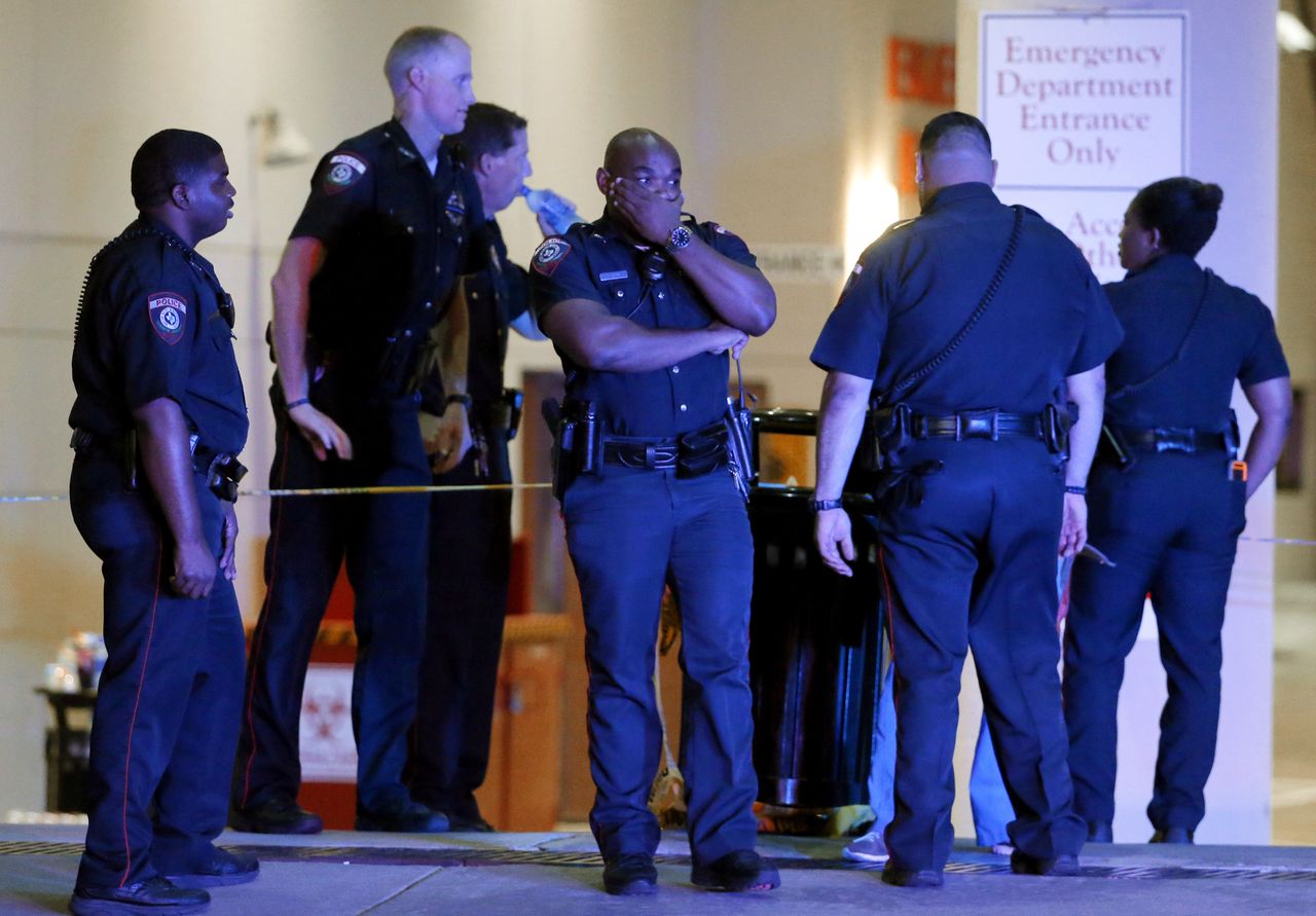 A police officer covers his face while standing outside the emergency room after the Dallas attacks.