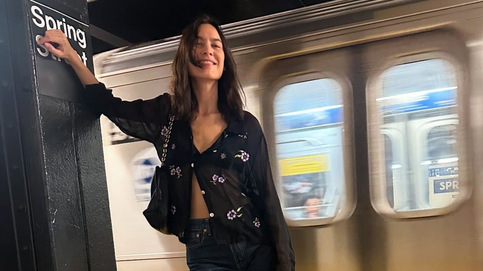 Alexa Chung wears skinny jeans with black patent leather ballet flats and a sheer blouse.