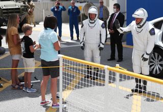 "NASA astronauts Bob Behnken (R) and Doug Hurley say goodbye to family members after walking out of the Operations and Checkout Building on their way to the SpaceX Falcon 9 rocket with the Crew Dragon spacecraft on launch pad 39A at the Kennedy Space Center on May 30, 2020 in Cape Canaveral, Florida."