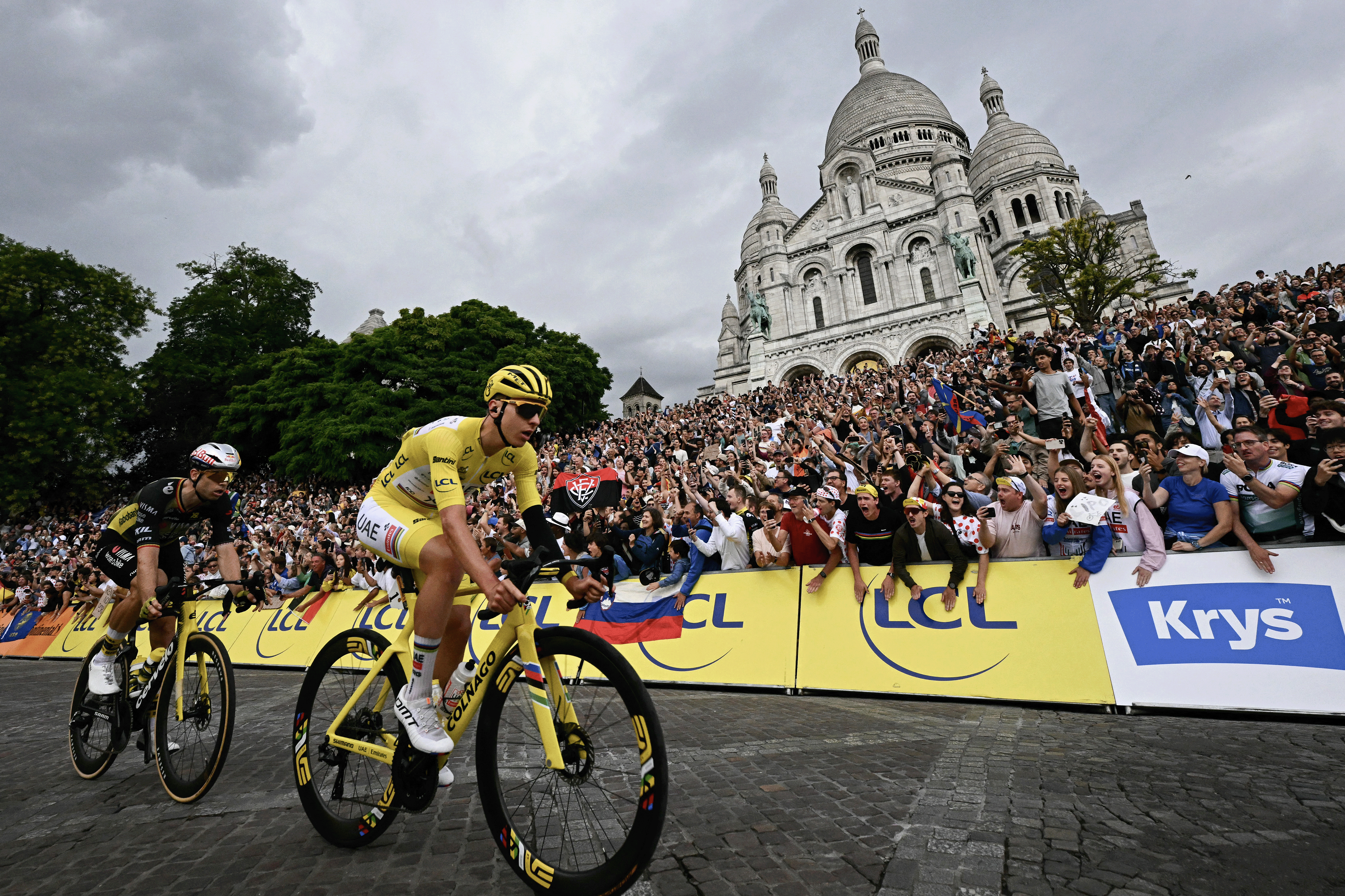 TOPSHOT - UAE Team Emirates - XRG team's Slovenian rider Tadej Pogacar wearing the overall leader's yellow jersey and Team Visma - Lease a bike team's Belgian rider Wout van Aert cycles past the Sacre-Coeur Basilica on the Butte de Montmartre during the 21st and final stage of the 112th edition of the Tour de France cycling race, 132.3 km between Mantes-la-Ville and Paris' Champs-Elysees Avenue, on July 27, 2025. (Photo by Loic VENANCE / AFP) (Photo by LOIC VENANCE/AFP via Getty Images)