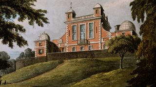 A painted brown brick building sits on a green hill