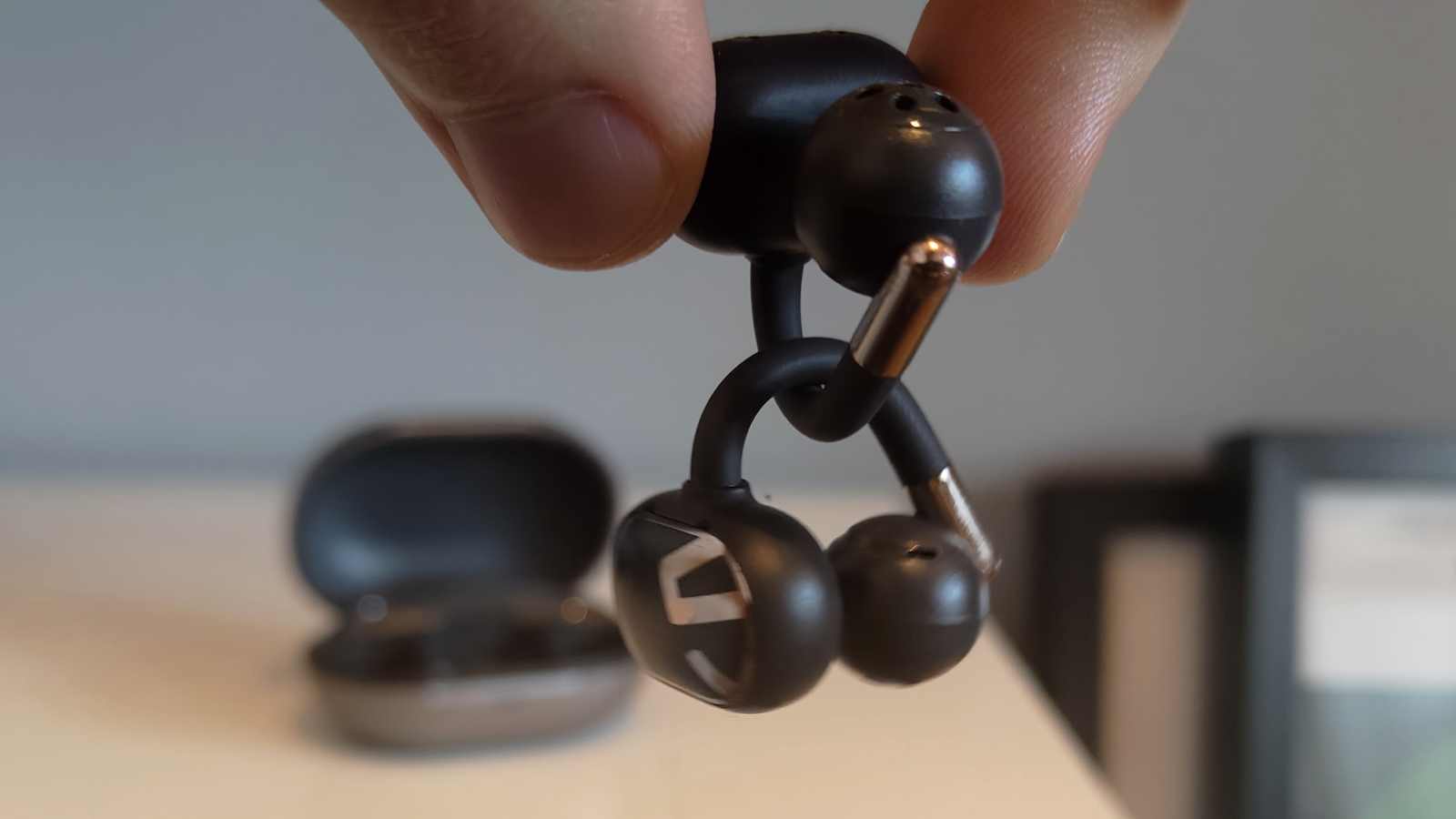 Two Soundpeats Clip1 buds hanging from each other.