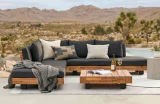 A wooden outdoor lounge set on a deck in the desert