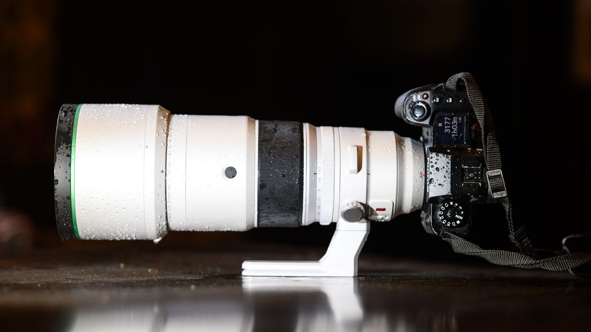 The Fujifilm XF 400mm F4.5 R LM OIS WR telephoto prime lens attached to a Fujifilm X-H2S camera, on a wooden table