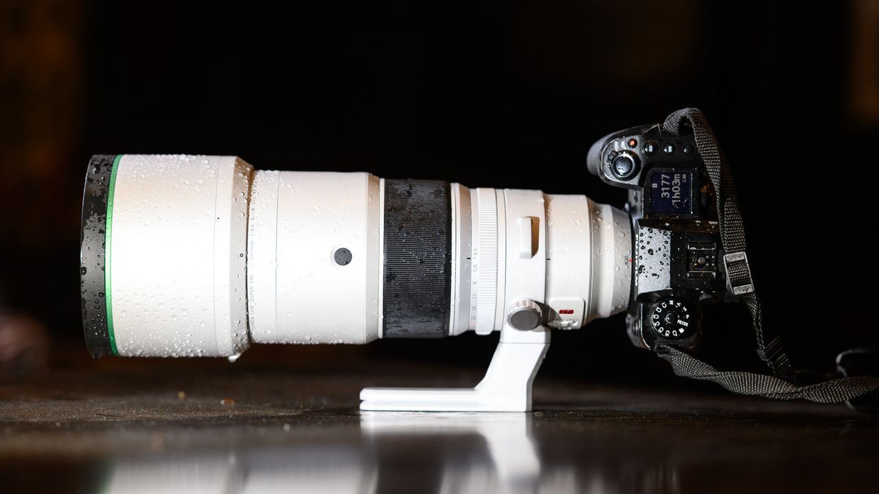 The Fujifilm XF 400mm F4.5 R LM OIS WR telephoto prime lens attached to a Fujifilm X-H2S camera, on a wooden table