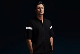 Viktor Hovland posing for a J Lindeberg shoot wearing a button-up black shirt