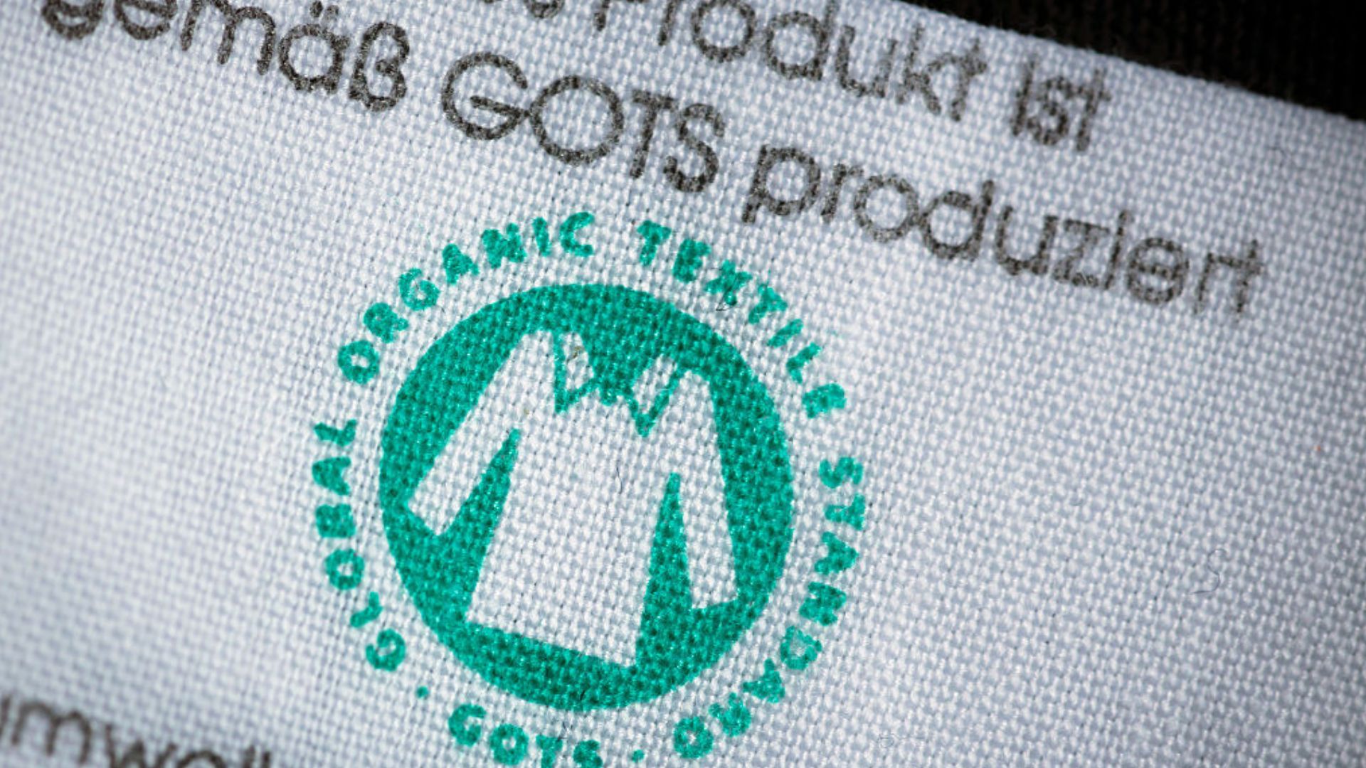 A white label showing the green GOTS certified circular logo with a white t-shirt in the middle which says 'Global Organic Textile Standard'