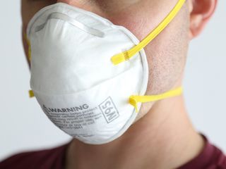 A man is shown wearing an N95 respirator mask, which is not intended to be reused.
