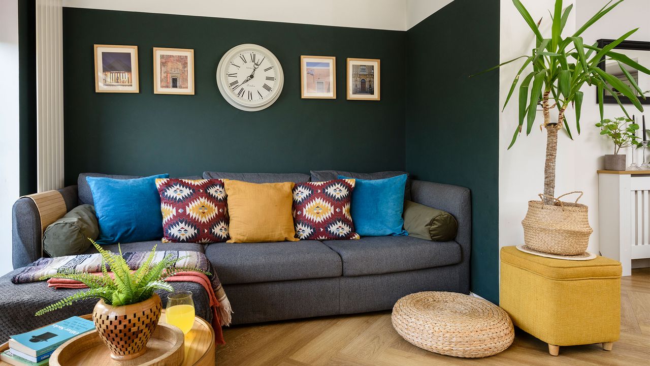 living room with green wall and grey sofa