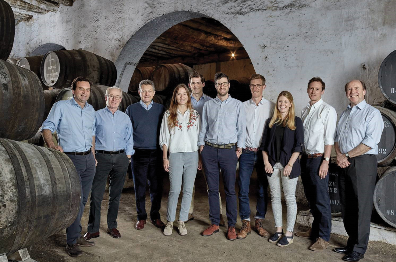 Nine members of the Symington family posing in the wine cellar