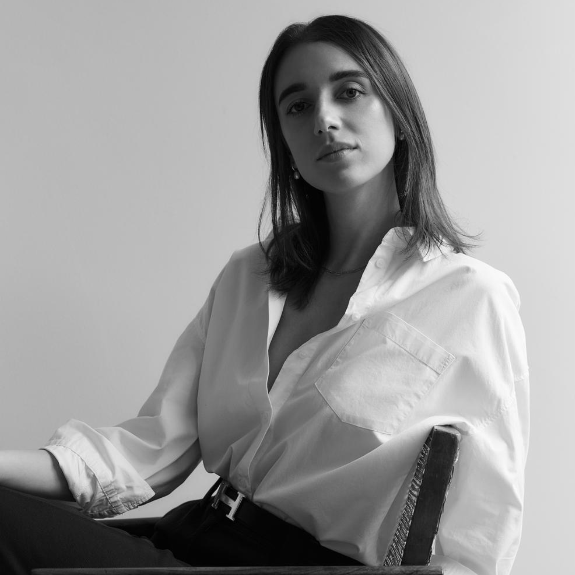 a woman in a white shirt sitting in a chair