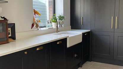 Floor-to-ceiling dark grey kitchen cabinets with grey concrete-effect floor tiles