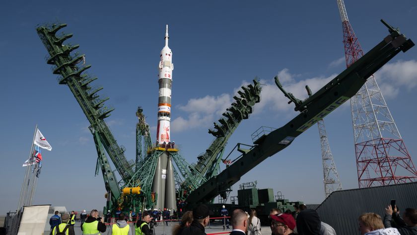 A Russian Soyuz rocket being prepared for a mission at Baikonur cosmodrome in Kazakhstan. The 20-ton service tower is seen opening around the rocket.