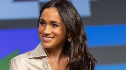 Meghan Markle wears a floral embroidered cape at an event