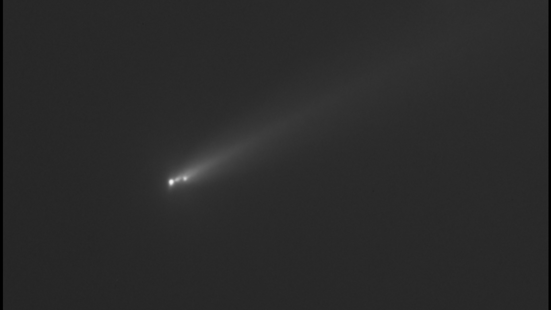 a black and white image of a comet streaking through outer space