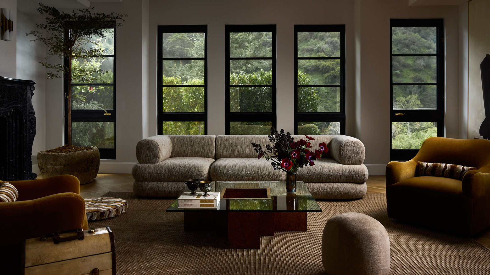 large living room with central gray sofa and big windows