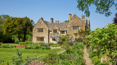 Exterior of Cotswold stone house with wisteria 