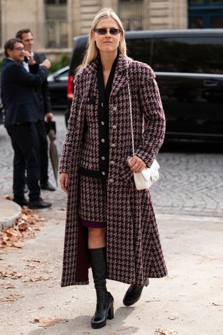 woman wearing a dogtooth coat and knee high boots