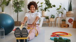 Woman holding resistance bands around feet