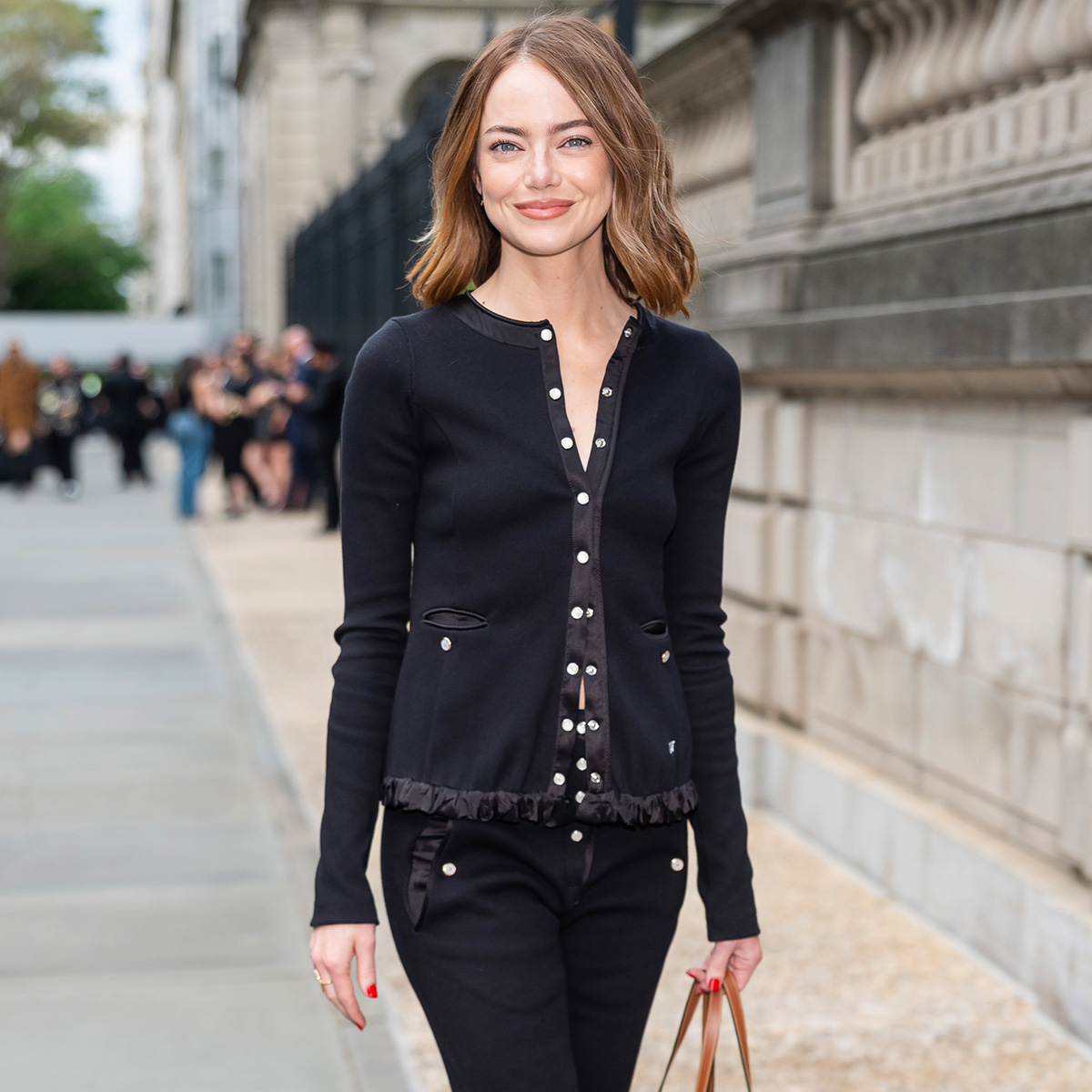 Emma stone wears a black jacket with black pants.