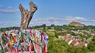 Ornaments and offerings for the Holy thorn with Glastonbury Tor in the background