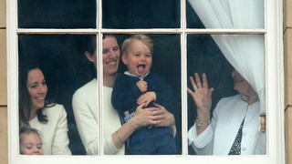 Prince George of Cambridge being held up at a window of Buckingham Palace by his nanny Maria Teresa Turrion Borrallo to watch Trooping the Colour on June 13, 2015 in London, England