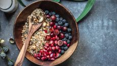 Gluten free breakfast cereal with fruit in wooden bowl