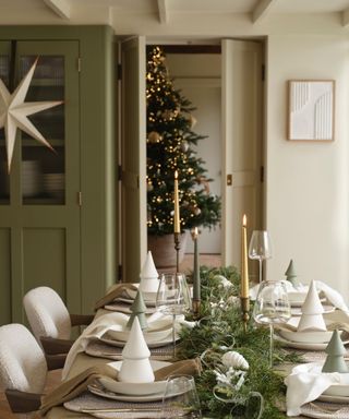 Scandinavian style christmas table with white and green decor and a long table garland